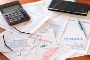 "Overdue Unpaid Bills on Table with Calculator and Cheque Book